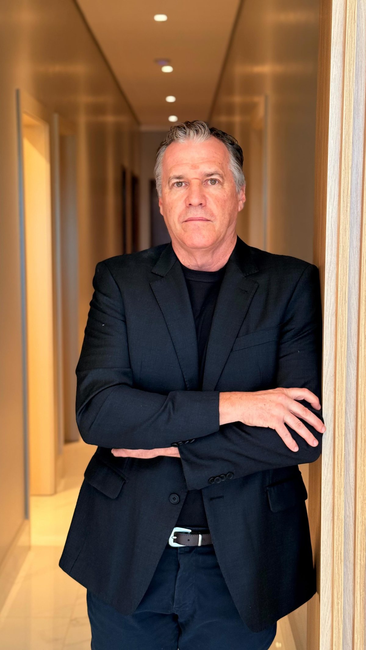 Retrato do Dr. Adriano Trevisi, de blazer preto e braços cruzados